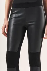 Pantalón negro de tiro medio, calce fit y largo al tobillo. Confeccionado en simil cuero con detalles en gamuza y cintura elástica.