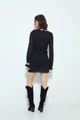 Vestido corto de manga larga acampanada, color marrón óxido, con textura acanalada y terminación ondulada en el ruedo.