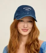 Gorra de sarga de algodón color azul denim, con visera curva y cierre ajustable con hebilla. Presenta bordado en blanco en la parte frontal con el texto "RIO DE JANEIRO BRASIL".
