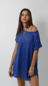 Vestido corto de tejido liviano con acabado brillante y caída fluida. Presenta un diseño holgado con escote amplio, mangas cortas y tajos laterales en el ruedo. Incluye forro interno para mayor comodidad.