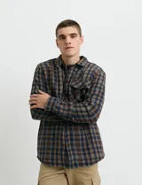 Sobrecamisa de manga larga con diseño a cuadros, cuello camisero y bolsillos laterales. Presenta un interior forrado con textura símil corderito y cierre frontal con botones.
