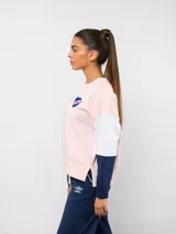 Buzo de cuello redondo con diseño de bloques de color en rojo, blanco y azul. Presenta el logo de Umbro y el escudo del Club Nacional de Football bordados en el pecho.