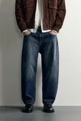 Jeans tapered wide fit de hombre, confeccionados en denim de algodón con efecto lavado en tono azul oscuro. Presentan diseño de cinco bolsillos, tiro medio, corte relajado y cierre frontal con cremallera y botón.