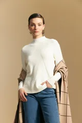 Polera de cuello alto en color blanco, confeccionada en tejido acanalado con un diseño geométrico de relieve que crea un efecto visual estilizado. Presenta un corte al cuerpo y mangas largas, ideal para usar como prenda base o principal.