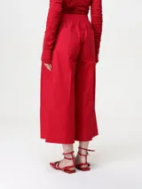 Pantalón cropped de popelina de algodón elástico color rojo, con cintura elástica, bolsillos inclinados, corte ancho y pinzas en la parte delantera.