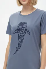 Remera de manga corta color azul con estampa frontal oscura de una ballena decorada con motivos florales.