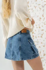 Minifalda de jean azul con bolsillos cargo frontales.