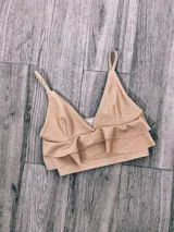 Top color rosa con breteles finos, escote en V y doble volado en el ruedo.