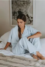 Conjunto de pijama azul a rayas blancas, compuesto por camisa de manga corta con botones y pantalón largo de corte amplio.