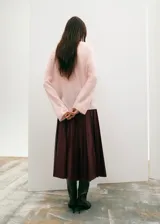 Falda midi plisada de cuero sintético en color bordó, con diseño de talle alto y corte recto.