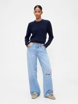 Buzo de algodón color crema con cuello redondo y diseño de punto trenzado en el frente.