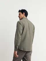 Camisa de manga larga confeccionada en una mezcla de algodón y lino, con cuello abotonado, bolsillo frontal en el pecho y cierre de botones.