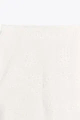 Bermuda negra de tiro alto confeccionada en hilatura de algodón con bordados perforados a tono, forro interior y cierre con cremallera oculta en costura.