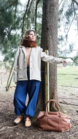 Bolso de viaje marrón de cuero napa fulonada, con doble asa de mano y cierre superior con cremallera.