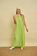 Vestido largo sin mangas de color verde lima, confeccionado en tela fluida y ligera, con escote redondo y corte amplio.