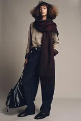 Bufanda de lana en color bordó con diseño de tejido en espiga y terminaciones con flecos en los extremos.