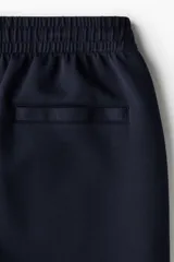 Short de felpa interlock color negro, de corte relajado a la rodilla, con cintura elástica con cordón ajustable oculto y bolsillos laterales.