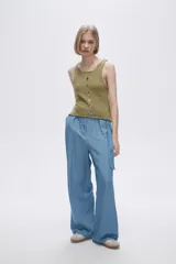 Musculosa verde melange de tejido de punto con tres aberturas circulares en el frente.