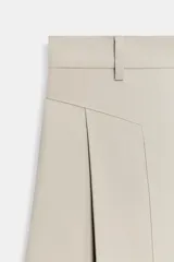 Pantalón de tiro medio con diseño de pierna ancha y pinzas frontales. Cuenta con bolsillos laterales ocultos, falsos bolsillos traseros de vivo, trabillas en la cintura y cierre frontal con cremallera y ganchos metálicos.