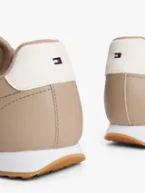 Zapatillas de corte bajo Tommy Hilfiger confeccionadas en piel napa color beige. Presentan paneles con mezcla de texturas, cordones tonales, suela de EVA blanca y detalle de contraste en el talón. Incluyen logo metálico de la marca en el lateral.