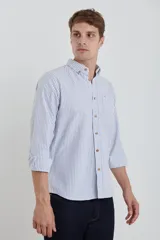 Camisa de manga larga con estampado de rayas verticales finas en tonos gris y blanco. Presenta cuello button-down, bolsillo frontal en el pecho y botones de madera.