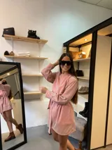 Vestido corto de lurex color salmón con brillo, escote redondo y mangas largas abullonadas. Incluye lazo para marcar la cintura.