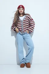 Cardigan de tejido de punto con diseño de rayas horizontales en tonos azul, gris y crema. Presenta escote en V, cierre frontal con botones grandes y mangas largas con puños anchos acanalados.