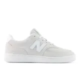 Championes New Balance modelo 80, color blanco hueso con detalles en blanco. Confeccionados en gamuza y malla, con el logo "N" característico en los laterales y suela de goma blanca.