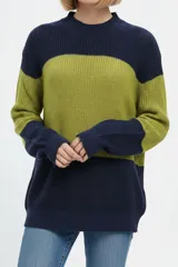 Sweater holgado de punto con cuello alto, diseño de franjas horizontales en azul marino y verde, y mangas largas.