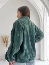 Camisa verde de pana con corte oversize, cuello clásico y cierre frontal con botones plateados.