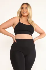 Top deportivo negro con tirantes finos y almohadillas removibles.