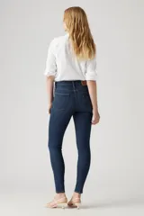 Jeans de tiro alto, color azul oscuro, corte ajustado en cadera y muslos, y pierna skinny.