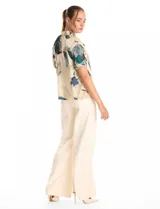 Blusa de gasa con estampado abstracto en tonos verdes, azules y beige. Presenta cuello mao fruncido con escote en V regulable mediante lazos, y mangas cortas con volados y puños elásticos.