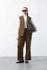 Chaleco de estilo utilitario color bordó con pespuntes blancos a contratono. Presenta solapas, cierre frontal con botones, bolsillos delanteros y un diseño estructurado.