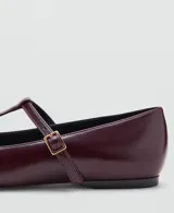 Zapato plano tipo Mary Jane, color bordó, de punta fina y tira en forma de T con hebilla metálica dorada ajustable.