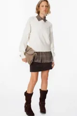 Sweater de silueta holgada en color crudo, con cuello redondo, mangas largas y puños anchos acanalados.