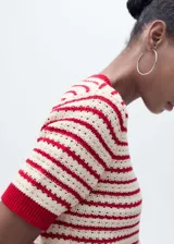 Jersey de punto crochet con diseño de rayas horizontales en color rojo y crema. Presenta cuello redondo, mangas cortas y terminaciones en rib acanalado de color rojo sólido.