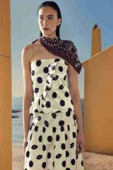 Falda midi de color blanco con estampado de lunares negros y labios.