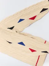 Sweater de punto con diseño de ochos en color verde, cuello redondo con detalle de franja en contraste, y apliques de rombos en las mangas. Presenta un bordado con la letra M en el pecho.