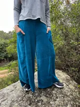 Pantalón palazzo de tiro alto, color azul, confeccionado en plush de algodón con faja ancha en la cintura y bolsillos laterales amplios.