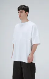 Remera de corte oversize color blanco, con cuello redondo y mangas cortas amplias. Presenta una costura horizontal decorativa en la parte media delantera.