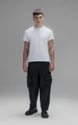 Pantalón cargo oversize de corte relajado, confeccionado en textil técnico resistente de color negro. Presenta bolsillos laterales cargo de gran tamaño con cierres metálicos, bolsillos laterales superiores y bolsillos traseros con broches a presión. Incluye cinturón integrado de cinta de seguridad con hebilla de encastre técnica.