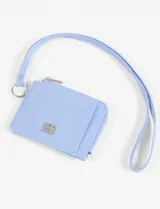 Tarjetero amarillo de cuero vegano con textura granulada, cierre superior con cremallera, tres ranuras para tarjetas y correa de muñeca.