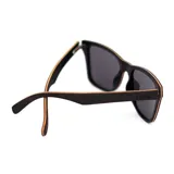 Lentes de sol con montura cuadrada de madera color negro y lentes verdes.