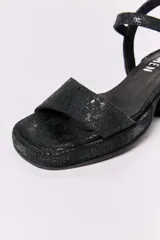 Sandalias negras de cuero con plataforma delantera y taco cuadrado.