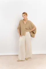 Camisa color crema de lino con mangas amplias y cinta en tono más oscuro en el cuello y la botonadura.