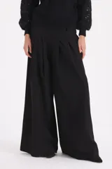 Pantalon de corte ancho y tiro alto, con pinzas frontales que aportan volumen y caída fluida.