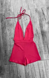 Mono corto de color rojo, con escote halter y espalda descubierta.
