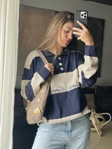 Sweater de punto con cuello polo y botones, a rayas horizontales color marrón y beige.