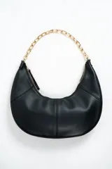 Cartera de mano tipo hobo color negro, de diseño curvo y estructura suave, con detalle de cadena metálica dorada y correa de hombro.